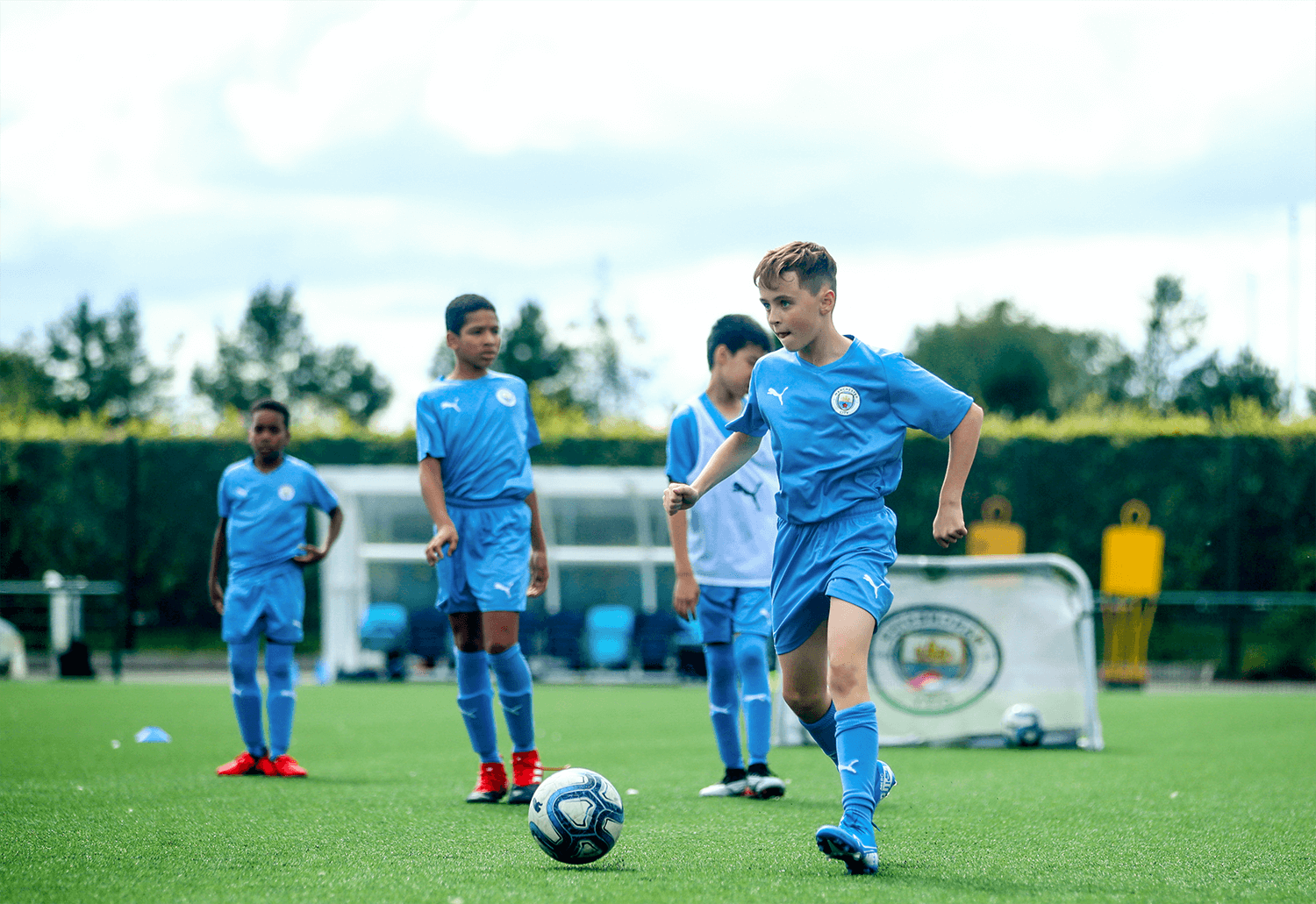 menino jogando bola no campo de futebol 